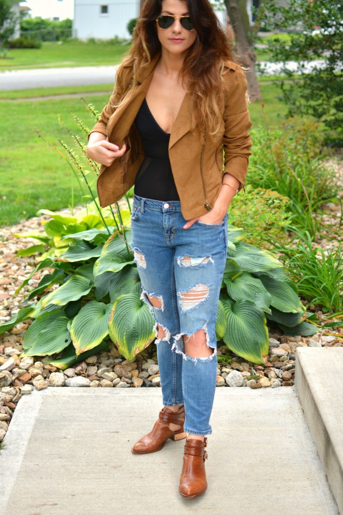 ashley from lsr in a faux suede jacket, ripped jeans, sheer bodysuit, and ankle booties