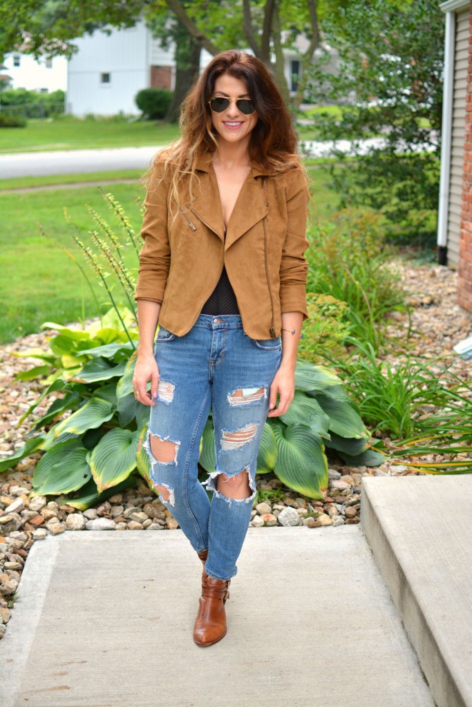 ashley from lsr in a faux suede jacket, ripped jeans, sheer bodysuit, and ankle booties