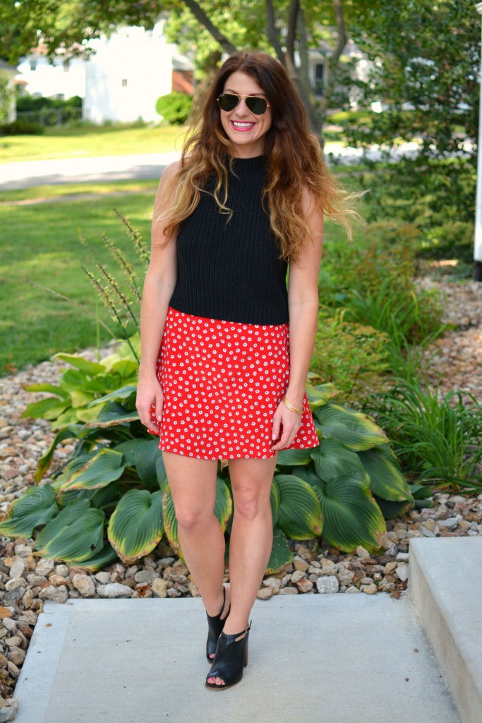ashley from lsr in a black cropped sweater and daisy skirt with black mules