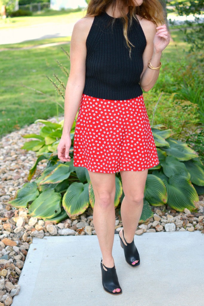 ashley from lsr in a black cropped sweater and daisy skirt with black mules