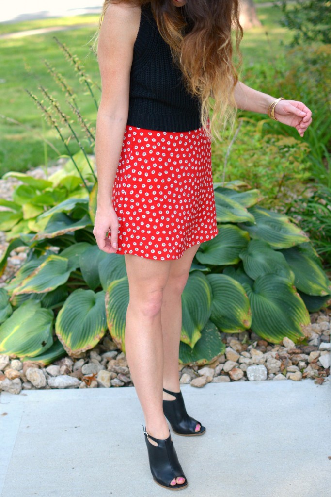 ashley from lsr in a black cropped sweater and daisy skirt with black mules