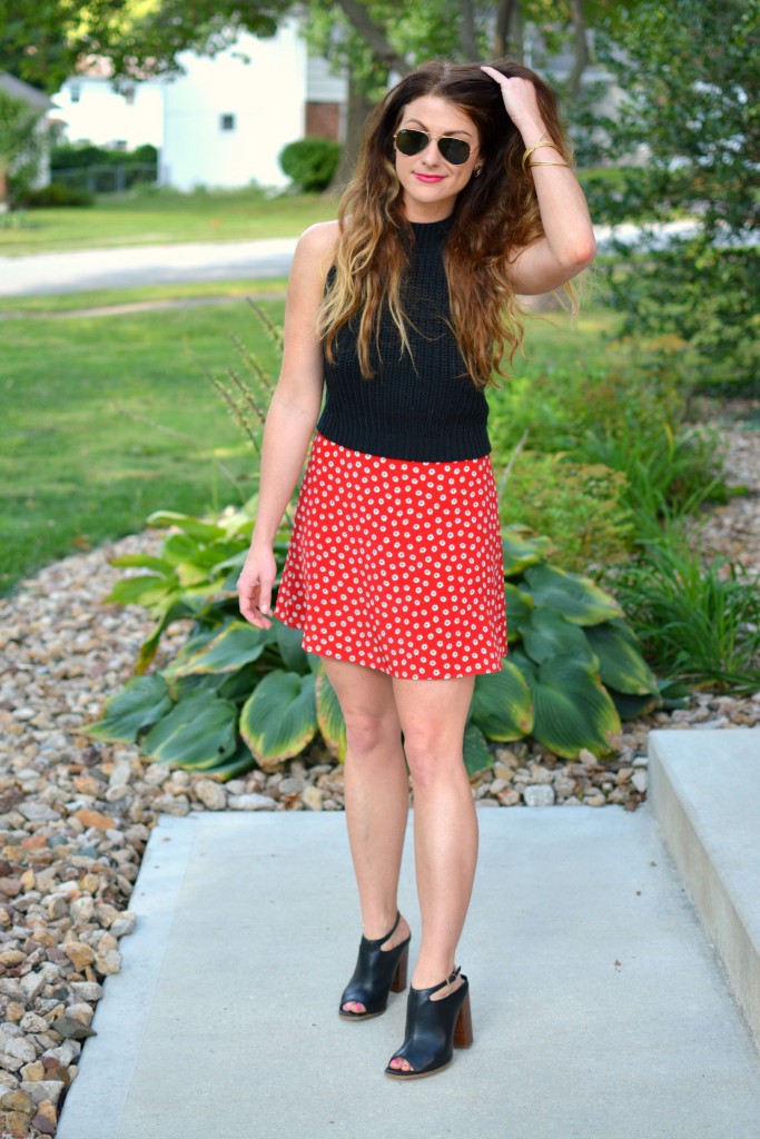 ashley from lsr in a black cropped sweater and daisy skirt with black mules