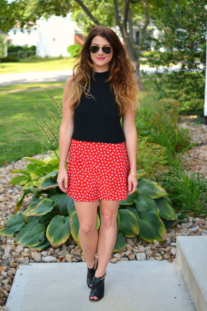 ashley from lsr in a black cropped sweater and daisy skirt with black mules
