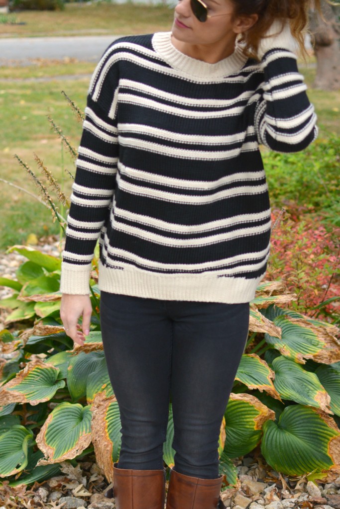 Ashley from LSR in a striped H&M sweater and black jeans, with riding boots.