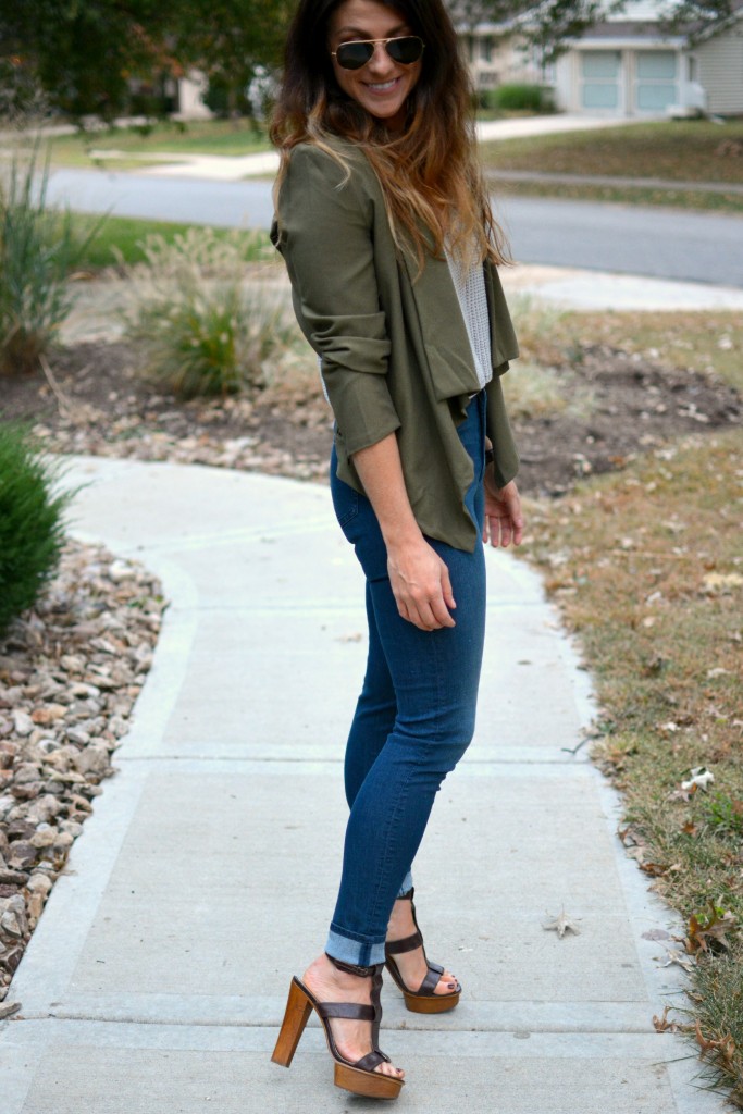 Ashley from LSR in an olive green jacket and gray crochet SheIn crop top, with high-waisted skinny jeans and gladiator sandals.