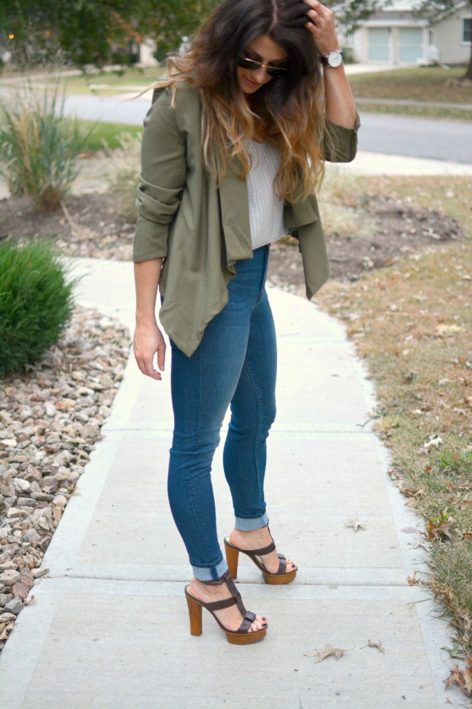 Ashley from LSR in an olive green jacket and gray crochet SheIn crop top, with high-waisted skinny jeans and gladiator sandals.