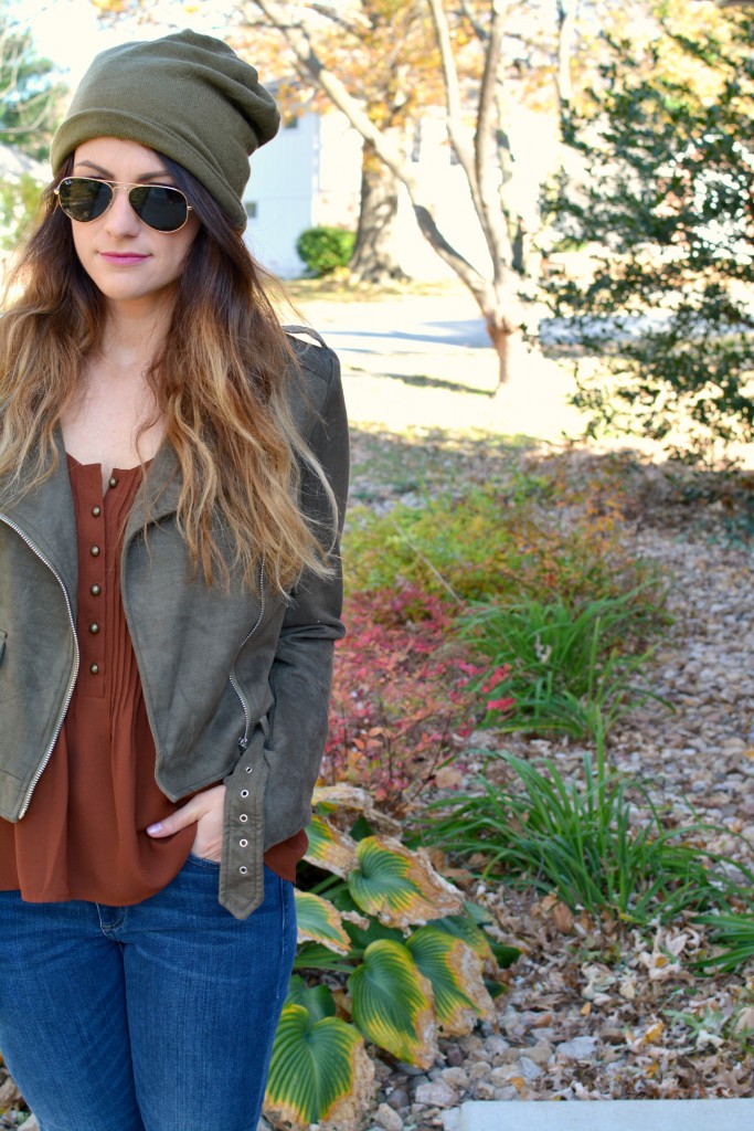 Ashley from LSR in an olive green beanie, olive green suede motorcycle jacket, and an Express tank.