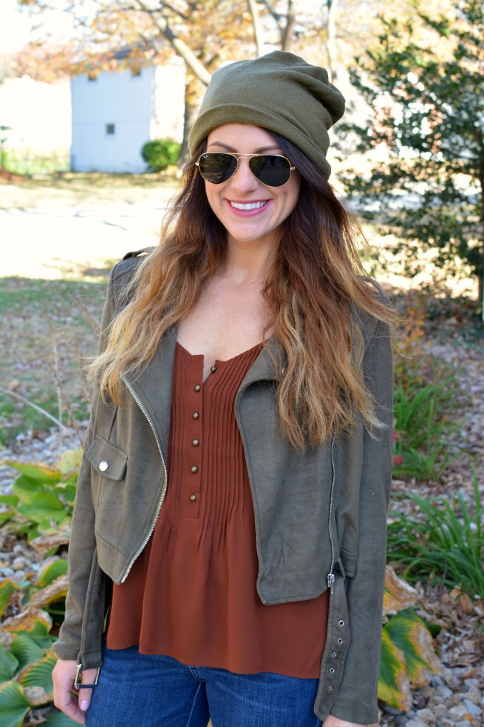 Ashley from LSR in an olive green beanie, olive green suede motorcycle jacket, and an Express tank.