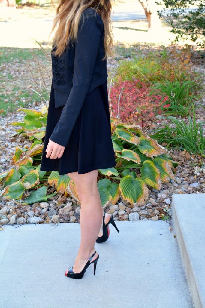 Ashley from LSR in a black turtleneck dress, black jacket, and Christian Louboutin pumps.