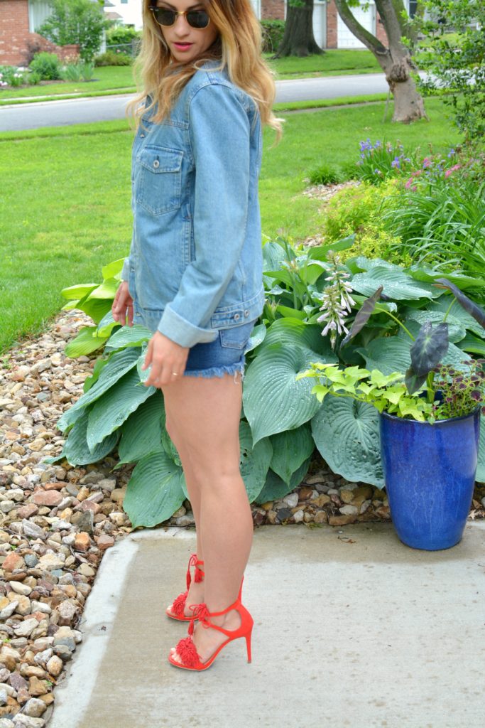 Ashley from LSR in a men's denim jacket, cutoff shorts, and red fringe sandals