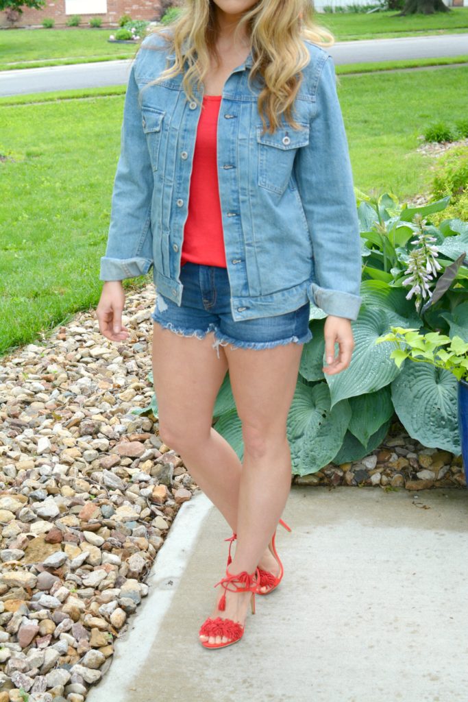 Ashley from LSR in a men's denim jacket, cutoff shorts, and red fringe sandals