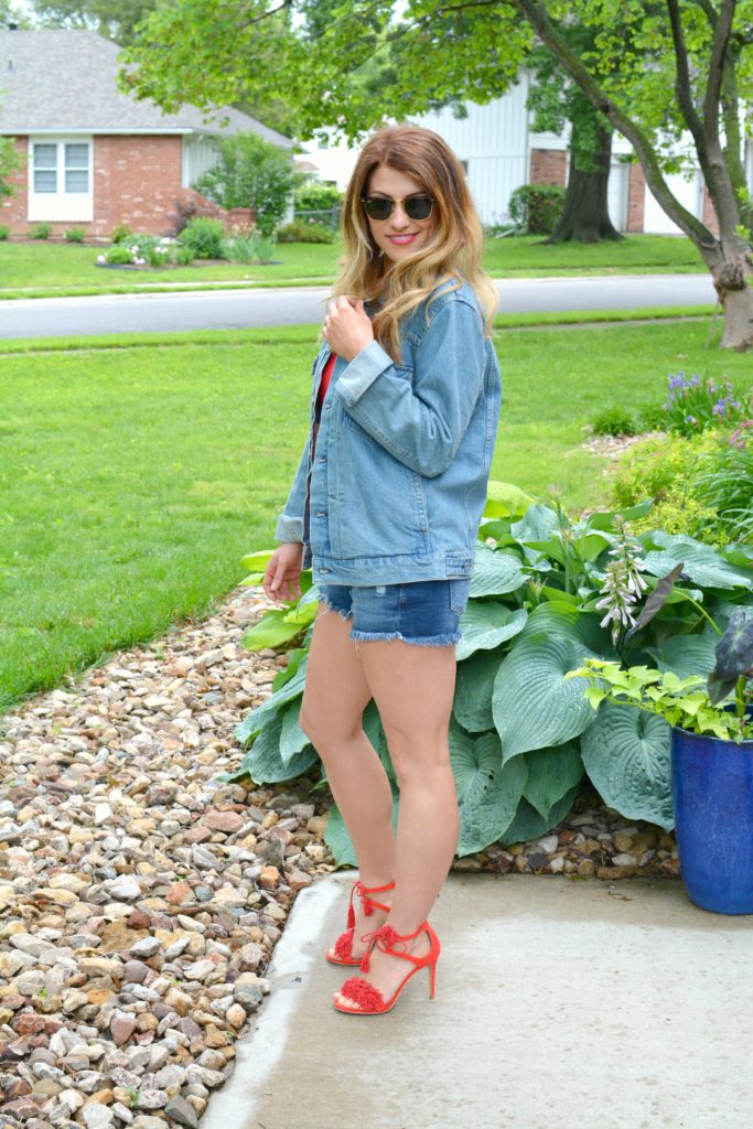 Ashley from LSR in a men's denim jacket, cutoff shorts, and red fringe sandals