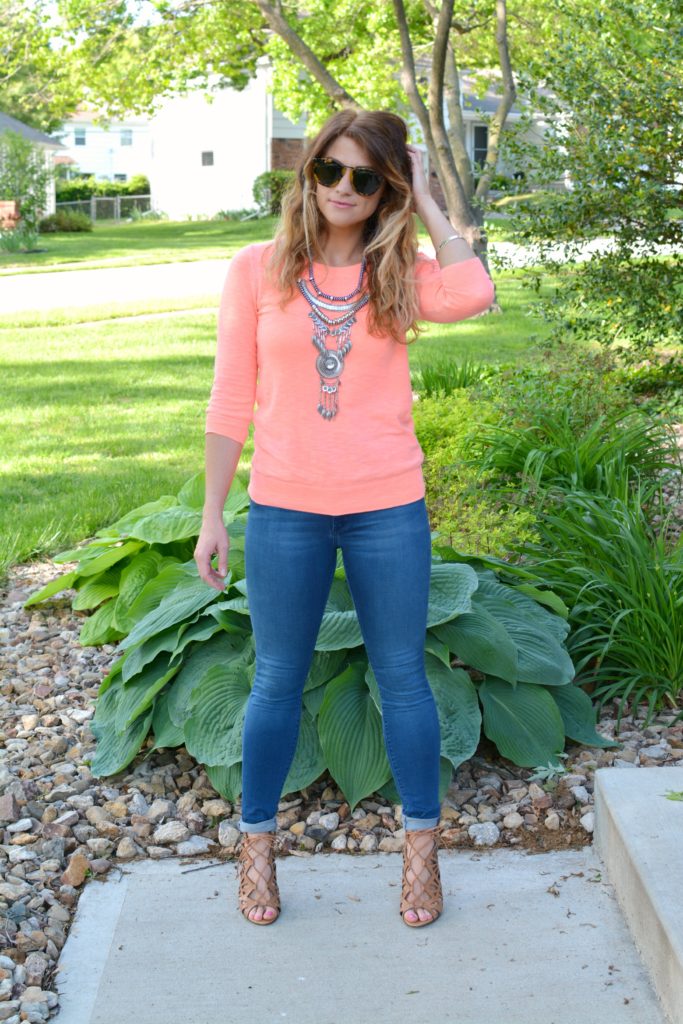 Ashley from LSR in a neon coral sweater and a silver statement necklace