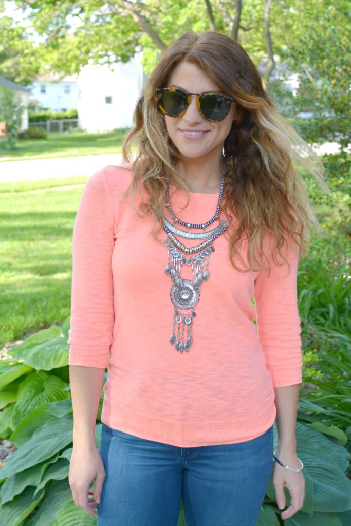 Ashley from LSR in a neon coral sweater and a silver statement necklace