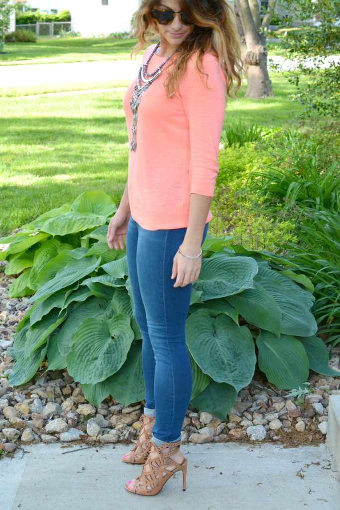 Ashley from LSR in a neon coral sweater and a silver statement necklace