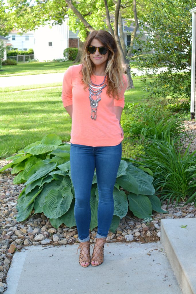 Ashley from LSR in a neon coral sweater and a silver statement necklace