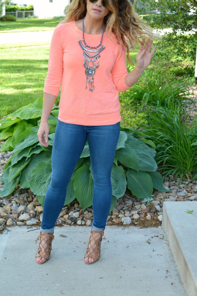 Ashley from LSR in a neon coral sweater and a silver statement necklace