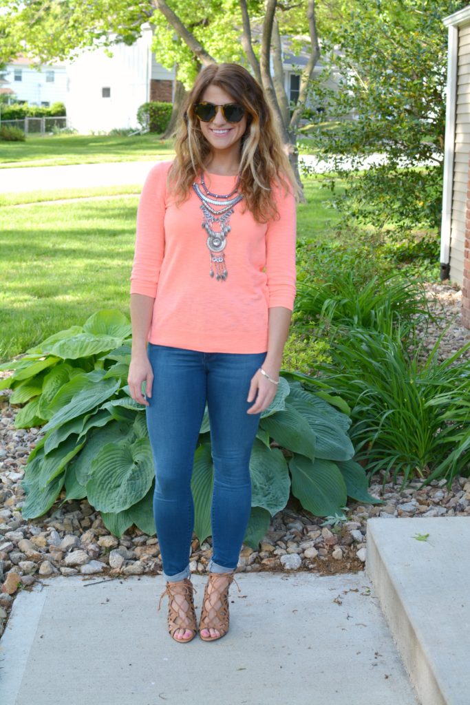 Ashley from LSR in a neon coral sweater and a silver statement necklace