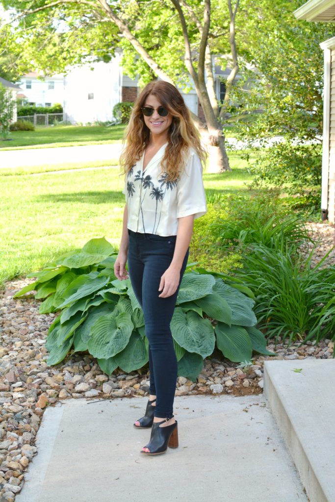 Ashley from LSR in a palm tree crop top, Frame jeans, and black mules
