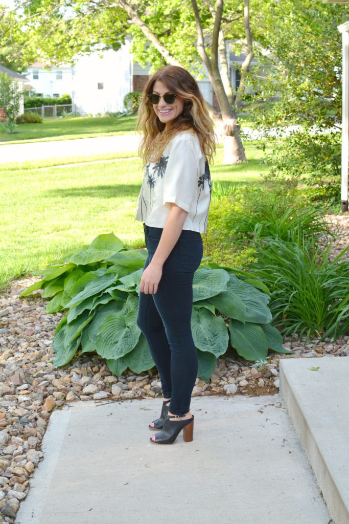 Ashley from LSR in a palm tree crop top, Frame jeans, and black mules