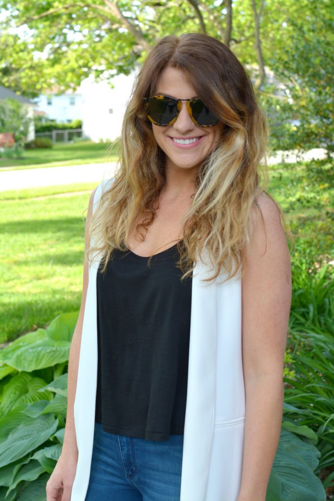 Ashley from LSR in a long white vest and Karen Walker Harvest sunglasses