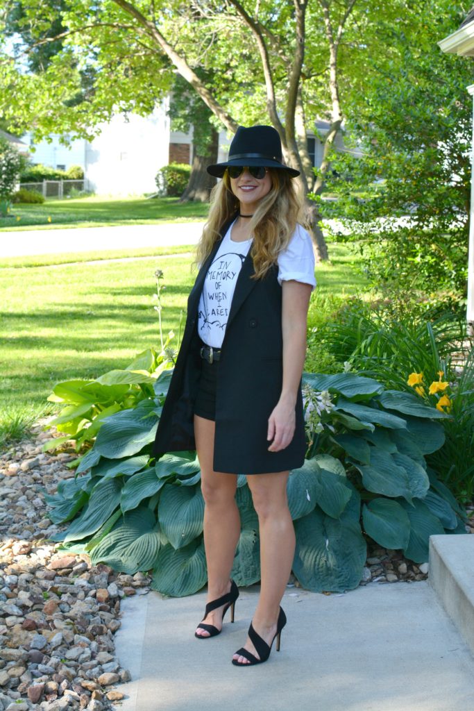 Ashley from LSR in a Sex & Ice Cream tee, long black vest, and black sandals