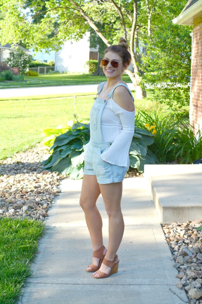 Ashley from LSR in overall shorts, a white tunic, and leather wedges