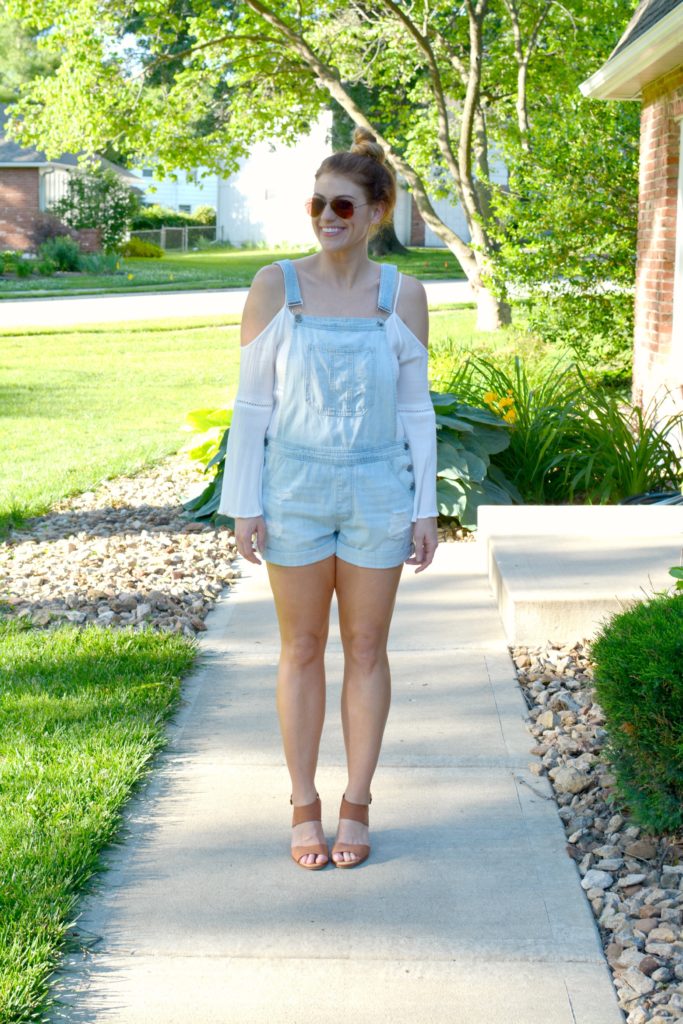 Ashley from LSR in overall shorts, a white tunic, and leather wedges