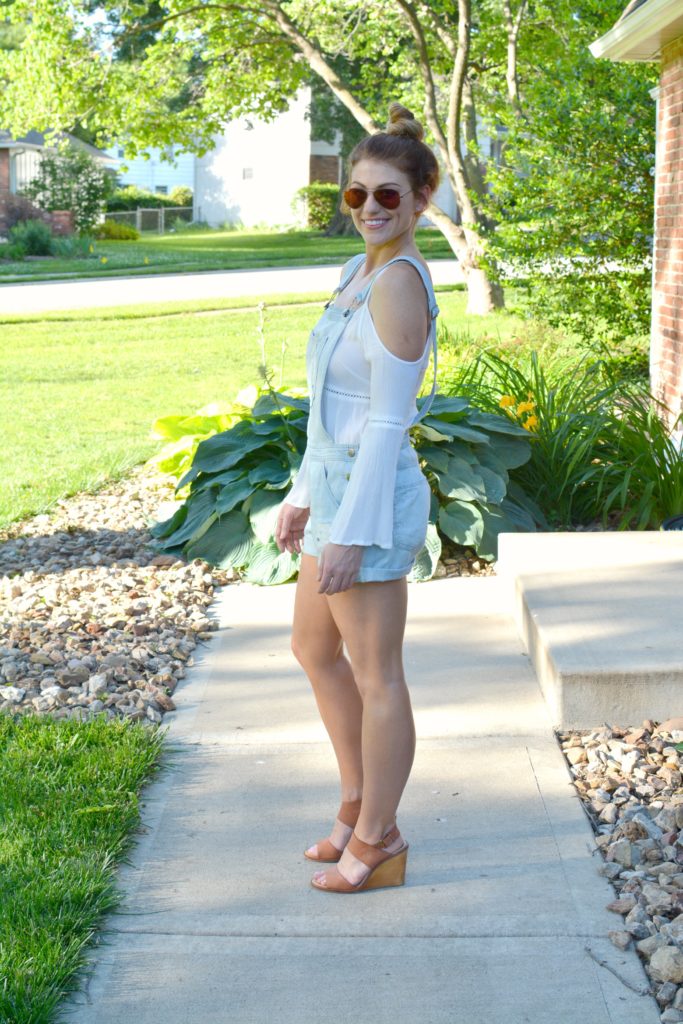 Ashley from LSR in overall shorts, a white tunic, and leather wedges