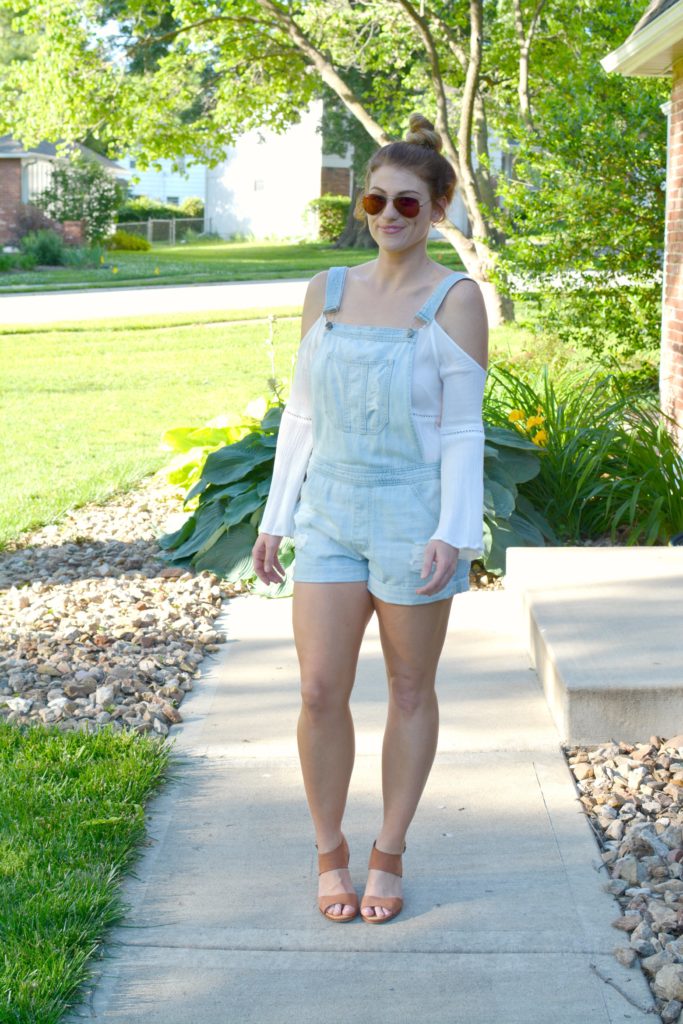 Ashley from LSR in overall shorts, a white tunic, and leather wedges