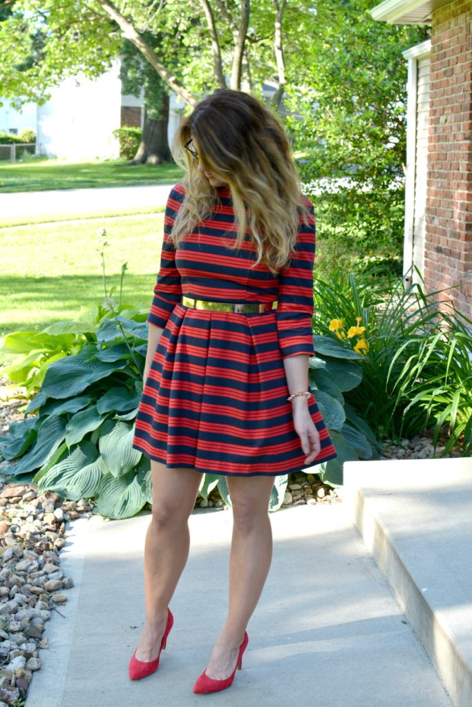 Ashley from LSR wearing a red and blue striped dress, red pumps, and metal belt