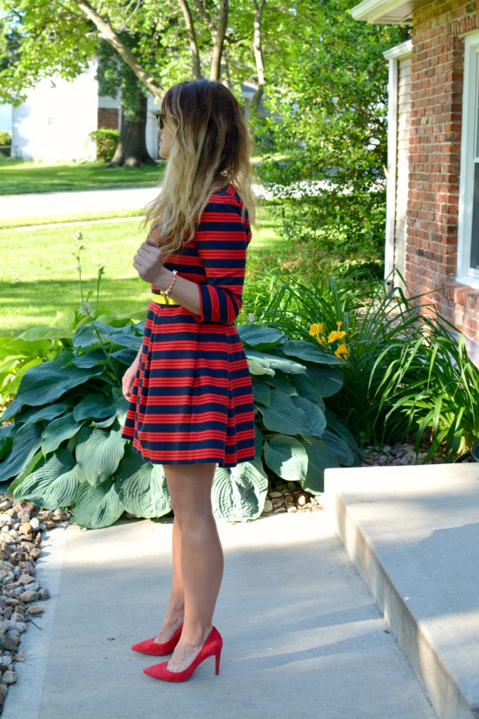 Ashley from LSR wearing a red and blue striped dress, red pumps, and metal belt