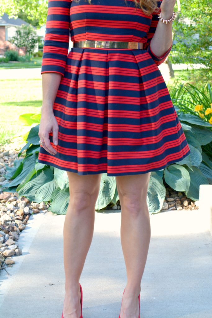 Ashley from LSR wearing a red and blue striped dress, red pumps, and metal belt