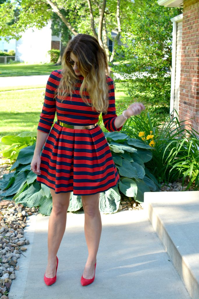 Ashley from LSR wearing a red and blue striped dress, red pumps, and metal belt