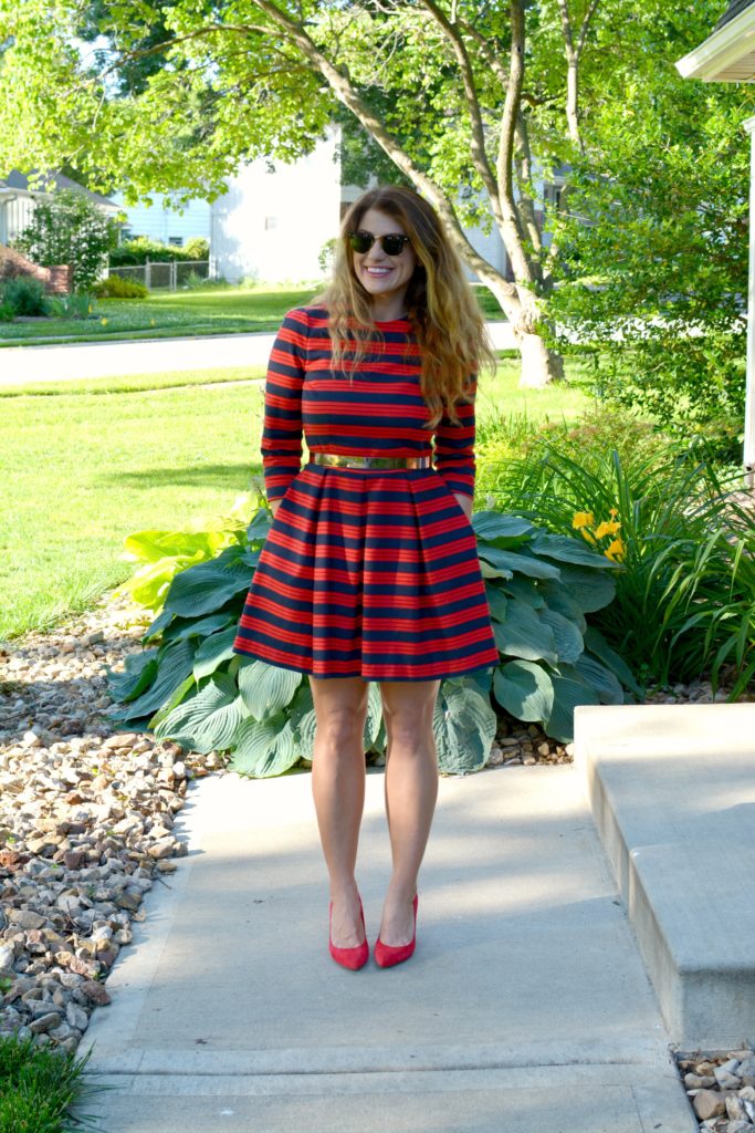 Ashley from LSR wearing a red and blue striped dress, red pumps, and metal belt