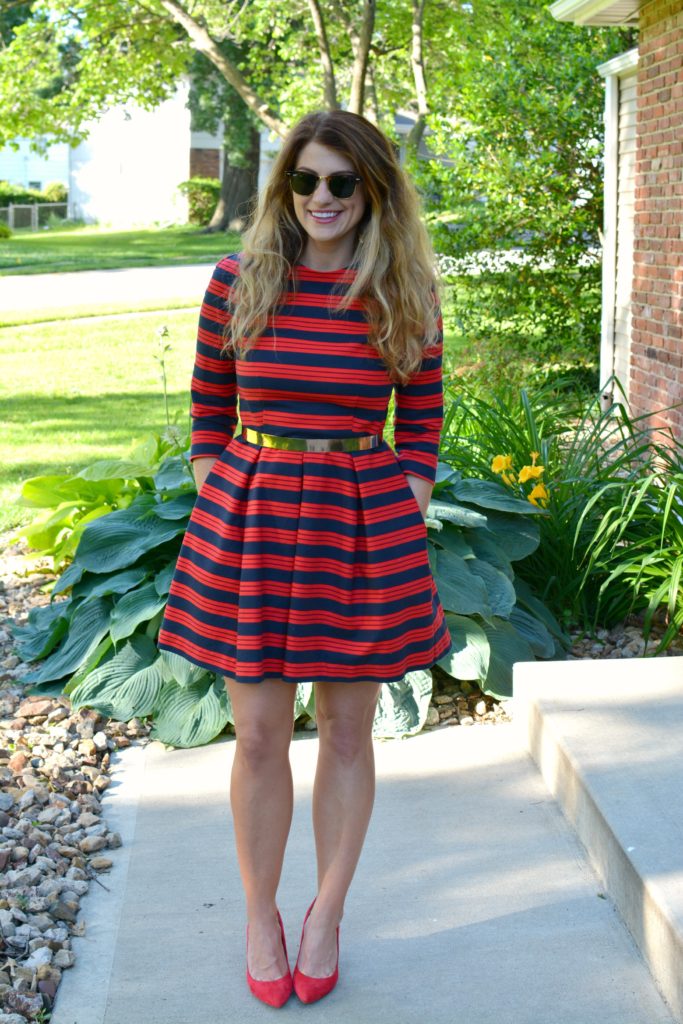 Ashley from LSR wearing a red and blue striped dress, red pumps, and metal belt