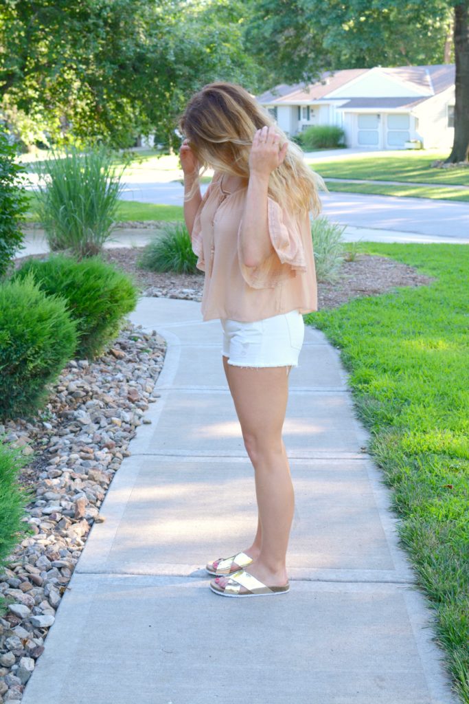 Ashley from LSR in a blush top from Zara, white denim shorts, and metallic slides