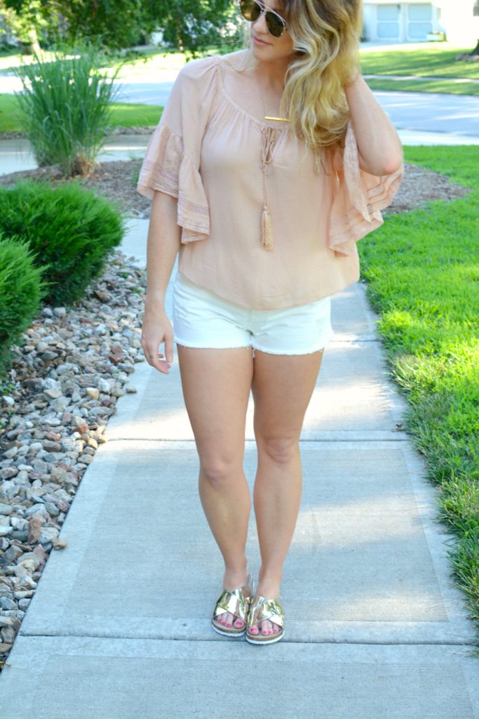 Ashley from LSR in a blush top from Zara, white denim shorts, and metallic slides