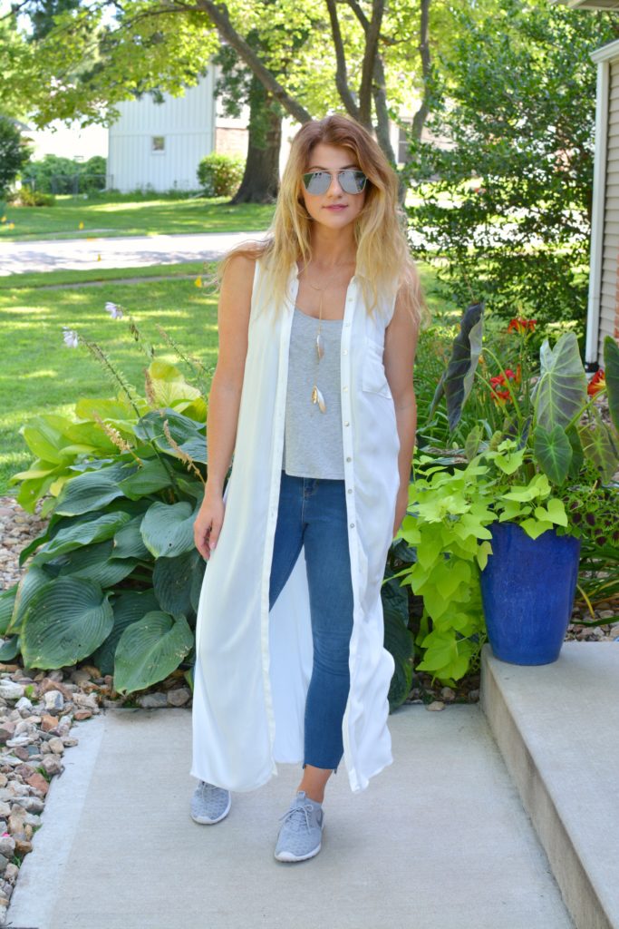 Ashley from LSR in a white duster, stepped hem jeans, and gray Nike's