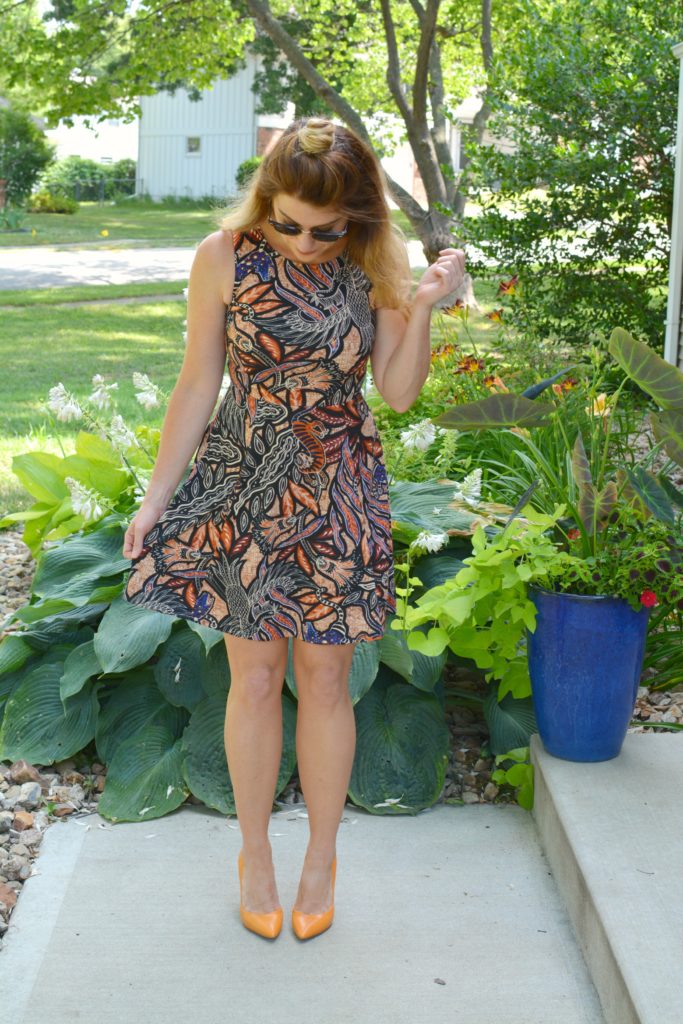 Ashley from LSR In a printed skater dress, black choker, and orange pumps