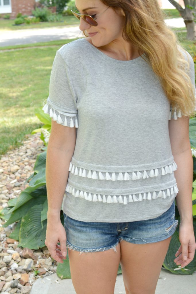Ashley from LSR in a gray tassel tee and cutoff shorts