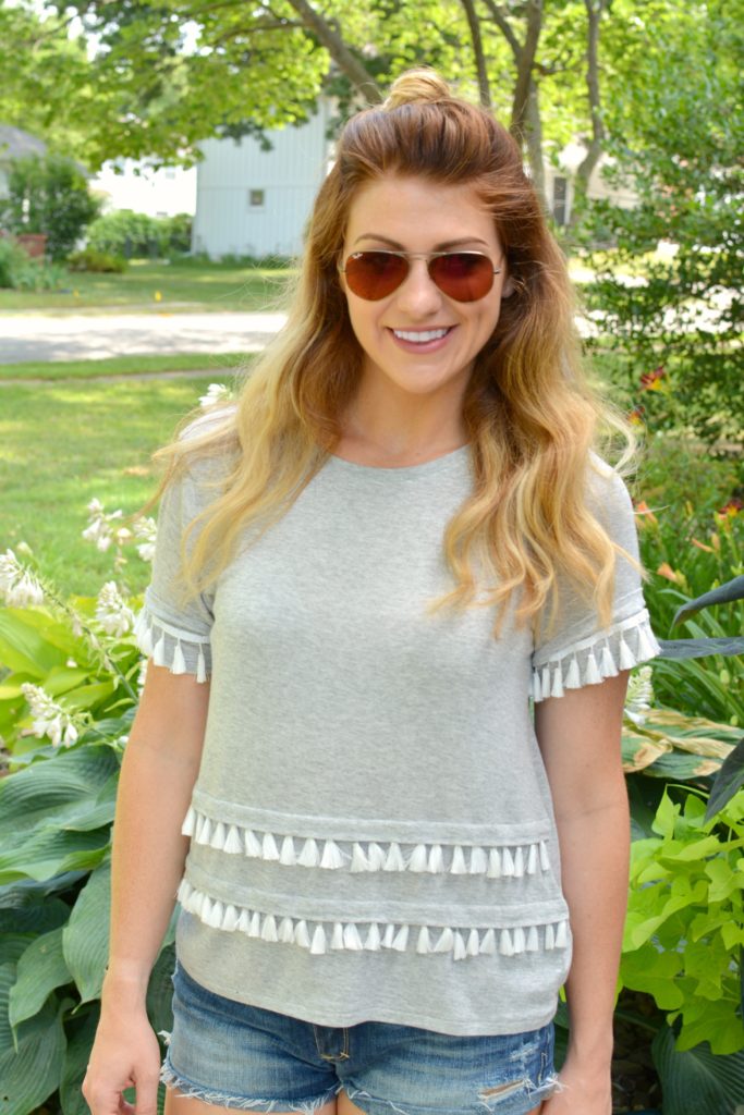 Ashley from LSR in a gray tassel tee and cutoff shorts