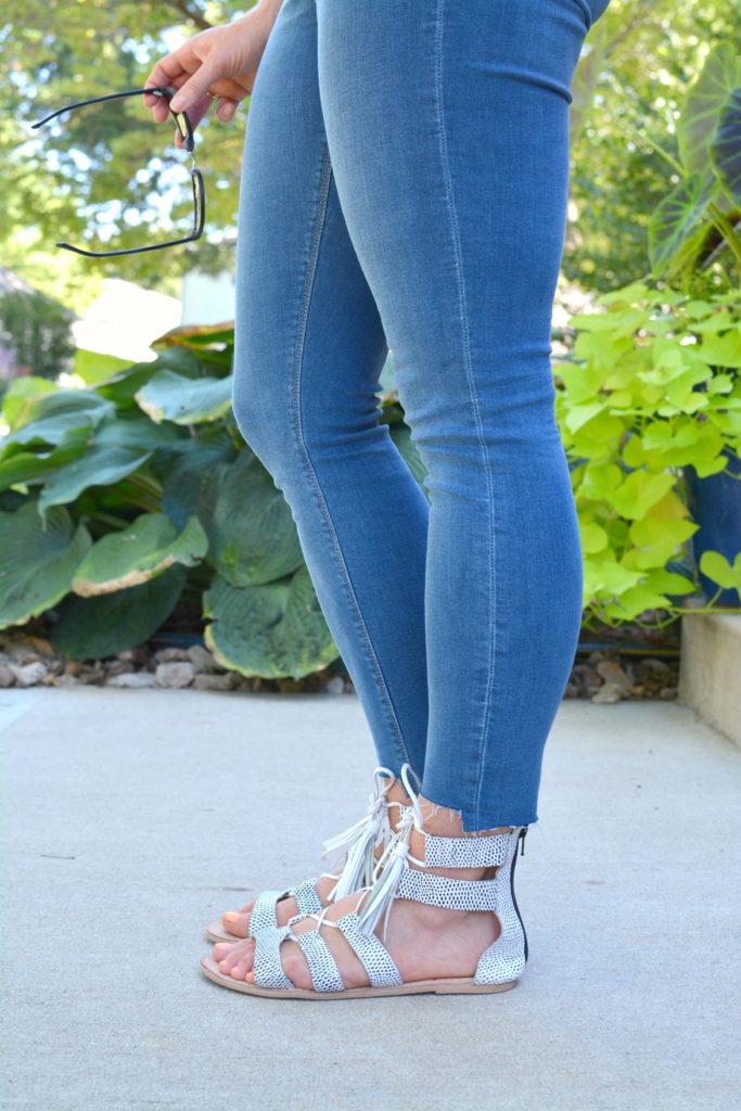 Ashley from LSR in stepped hem jeans and white lace-up sandals