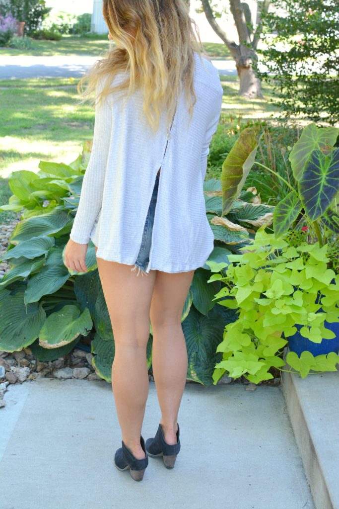 Ashley from LSR wearing a lightweight sweater, One Teaspoon shorts, and ankle boots