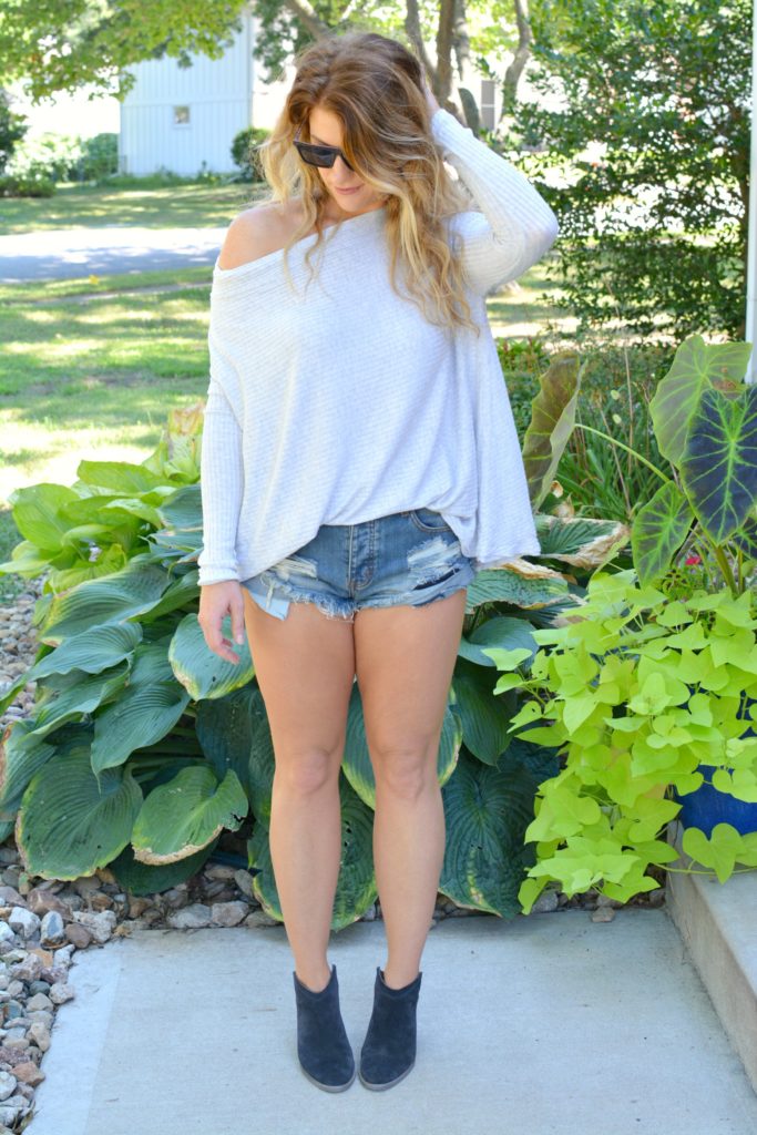 Ashley from LSR wearing a lightweight sweater, One Teaspoon shorts, and ankle boots