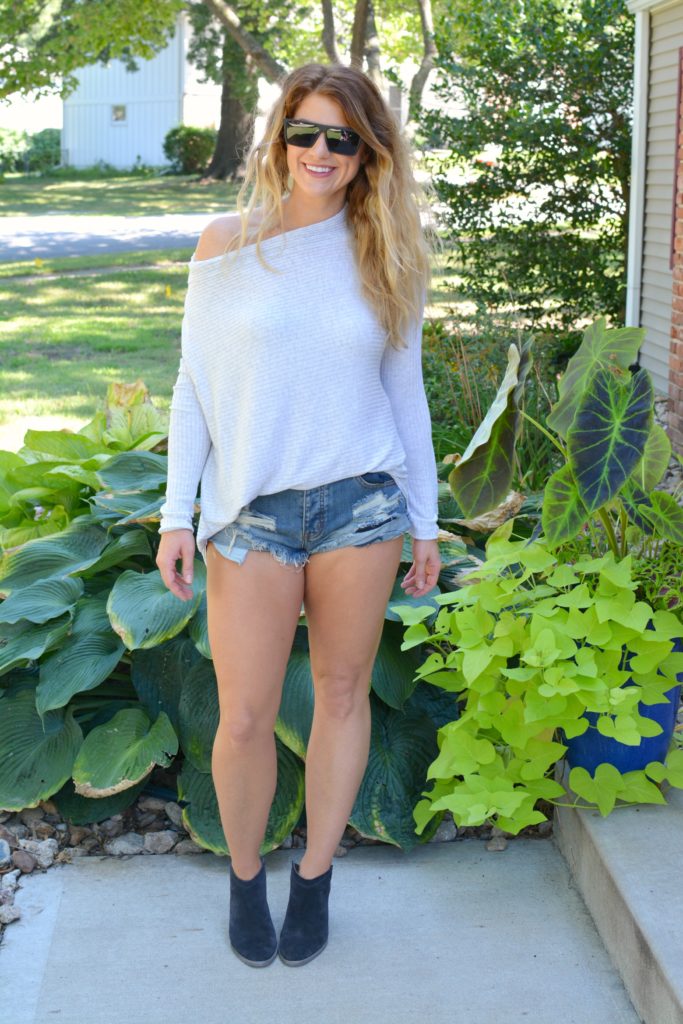Ashley from LSR wearing a lightweight sweater, One Teaspoon shorts, and ankle boots