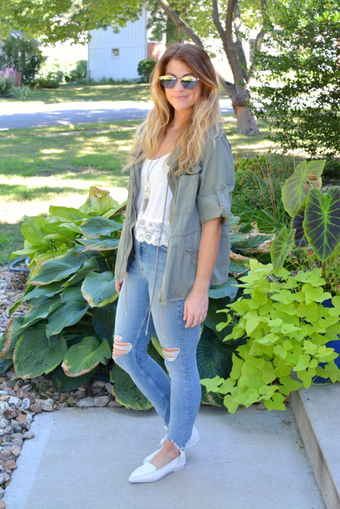 Ashley from LSR in an olive green utility jacket, destroyed denim, white loafers, and Fendi sunglasses