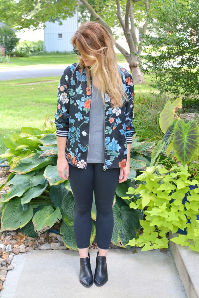 Ashley from LSR wearing a floral bomber jacket from H&M with black leggings and ankle boots