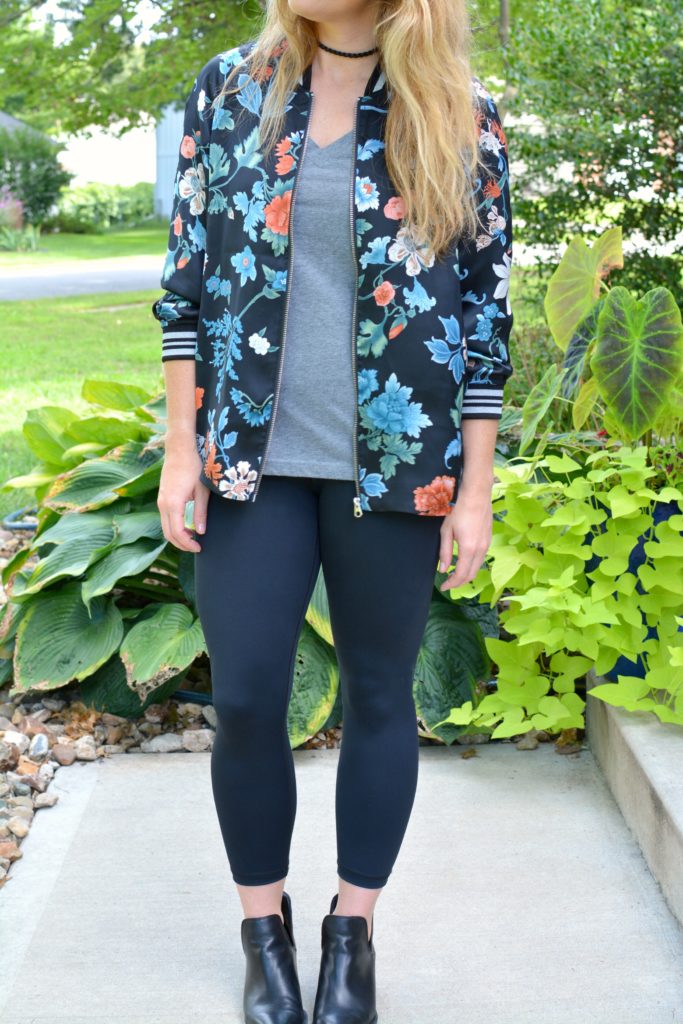 Ashley from LSR wearing a floral bomber jacket from H&M with black leggings and ankle boots