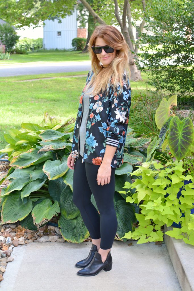 Ashley from LSR wearing a floral bomber jacket from H&M with black leggings and ankle boots